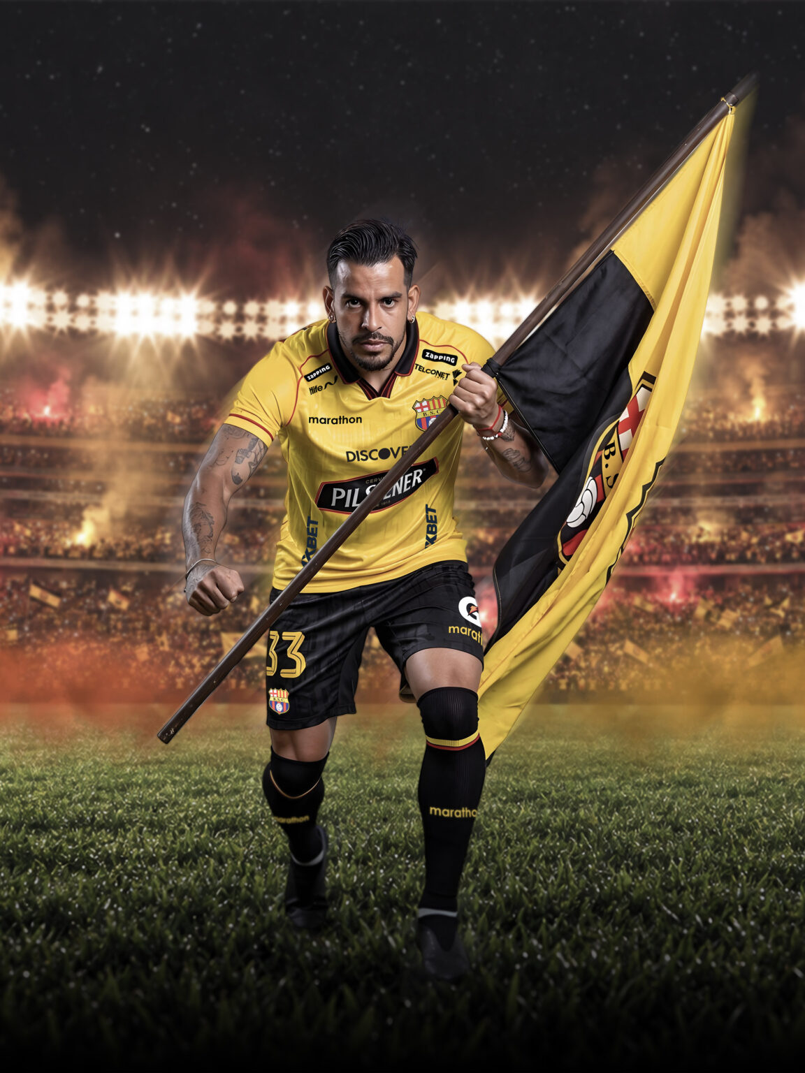 Jugador de Barcelona Sporting Club avanza sosteniendo una bandera amarilla y negra, con el Estadio Banco Pichincha de fondo, previo al partido ante Universidad Católica.