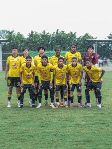 Equipo U15 de Barcelona SC posa en la cancha bajo la lluvia antes de un partido.